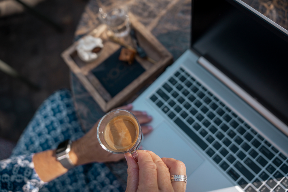 Symbolisch beeld van persoonlijke ondersteuning en vertrouwen – koffiegesprek bij laptop, passend bij de rol van extern vertrouwenspersoon